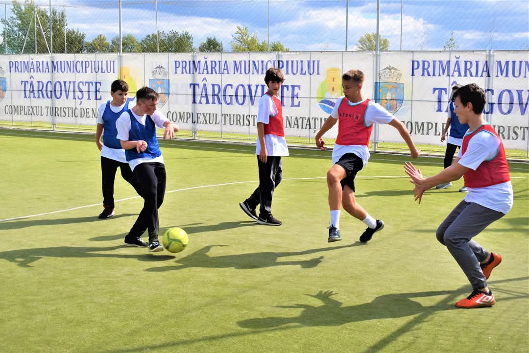 Elevii din Dâmbovița joacă fotbal în vacanță, la Complexul Turistic de Natație Târgoviște. Sportul și mișcarea în aer liber se află în centrul activităților dedicate elevilor, în această vacanță, la Complexul Turistic de Natație Târgoviște. Zeci de copii și adolescenți participă la meciuri de fotbal amicale, într-o atmosferă de competiție, fair-play și voie bună.